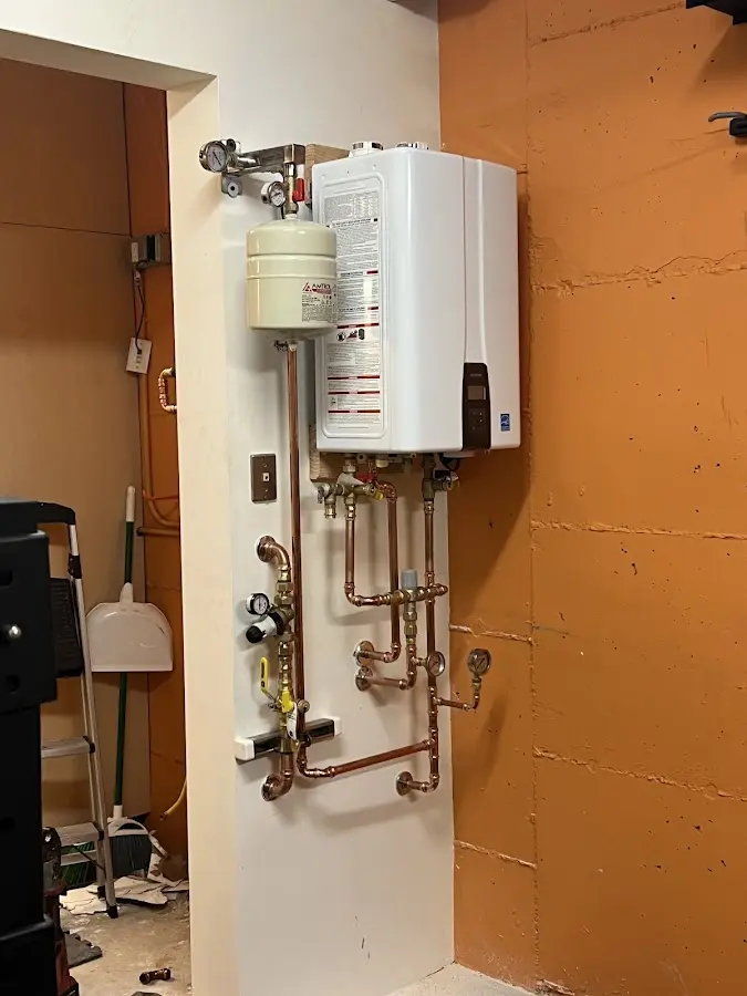 Plumbing technician inspecting water heater connections in Greenbriar